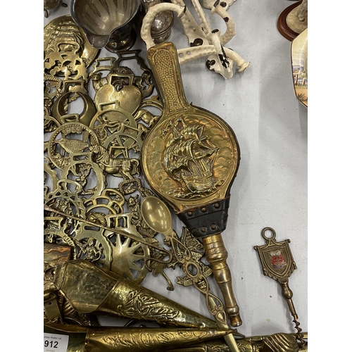 912 - A LARGE QUANTITY OF BRASS ITEMS TO INCLUDE HORSE BRASSES, BELLOWS, PISTOLS ETC