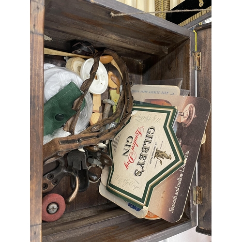 915 - A WOODEN BOX CONTAINING VARIOUS ITEMS TO INCLUDE STAMPS, PENS, HOOKS, BEER MATS ETC