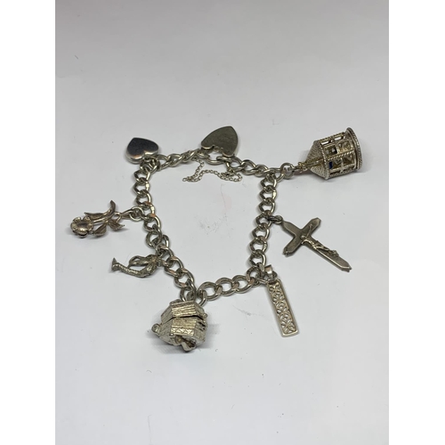 545 - A SILVER BRACELET WITH SEVEN VARIOUS CHARMS