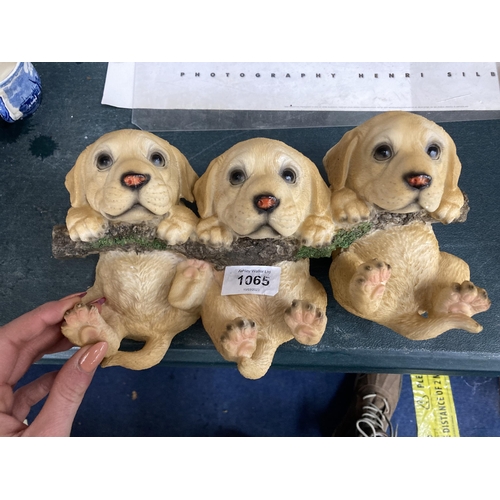 1065 - A RESIN COAT HANGER OF THREE GOLDEN LABRADOR PUPPIES