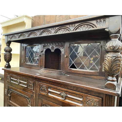 2682 - A REPRODUCTION OAK COURT CUPBOARD WITH GLAZED AND LEADED UPPER PORTION, 50