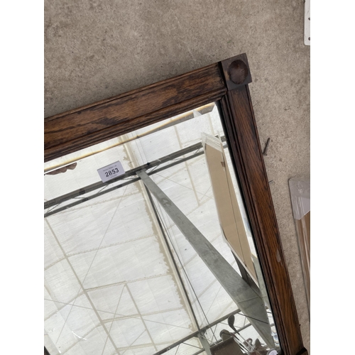 2853 - AN OAK FRAMED WALL MIRROR AND SILVER COLOURED MIRROR