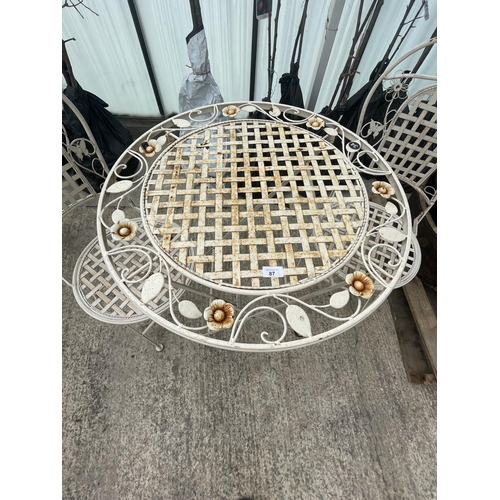 87 - A DECORATIVE METAL BISTRO TABLE COMPRISING OF A ROUND TABLE AND TWO CHAIRS NO VAT