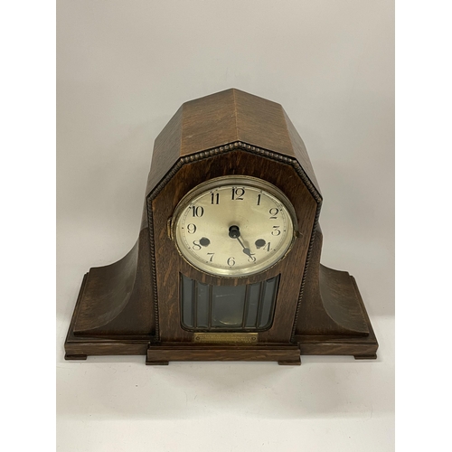 42 - AN EARLY 20TH CENTURY OAK CHIMING MANTLE CLOCK WITH PRESENTATION PLAQUE DATED 1924