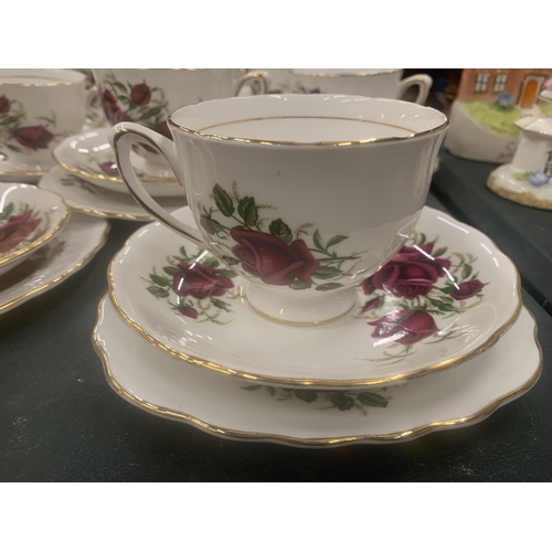 117 - A COLCLOUGH TEASET WITH ROSE PATTERN TO INCLUDE CUPS, SAUCERS, SIDE PLATES, A CAKE PLATE, CREAM JUG ... 