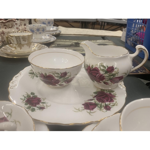 117 - A COLCLOUGH TEASET WITH ROSE PATTERN TO INCLUDE CUPS, SAUCERS, SIDE PLATES, A CAKE PLATE, CREAM JUG ... 