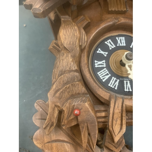 124 - A WOODEN CUCKOO CLOCK WITH ANIMAL CARVING