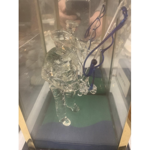 135 - A GLASS FIGURE OF A FISHERMAN IN A GLASS DISPLAY CASE