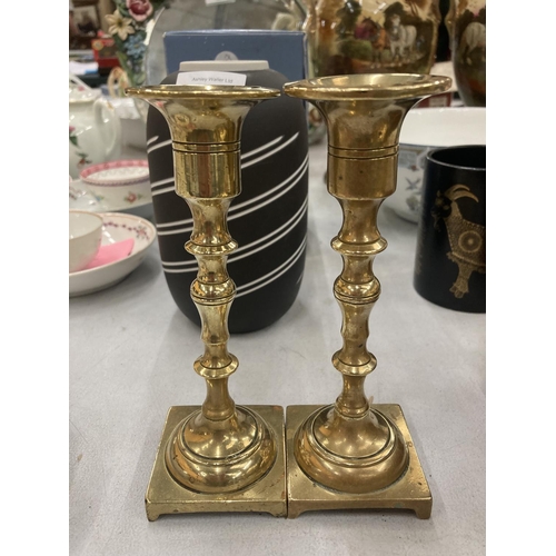 214 - A PAIR OF VINTAGE BRASS CANDLESTICKS AND A BRASS PIG MONEY BOX