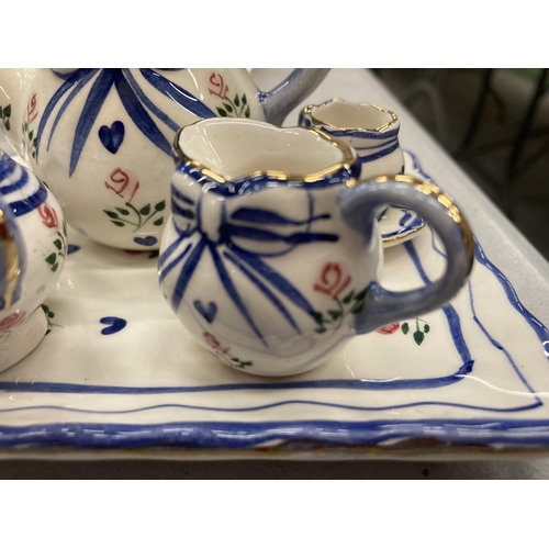 224 - A MINIATURE CERAMIC TEASET ON A TRAY