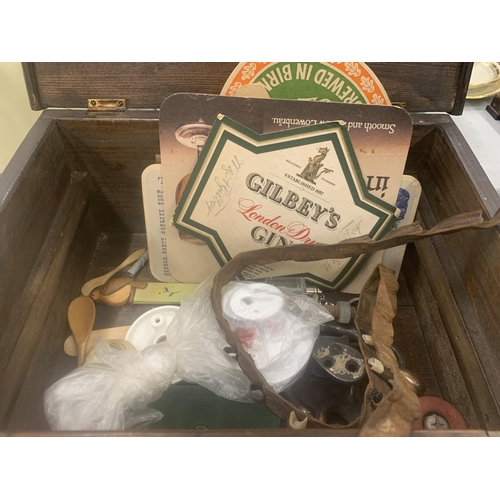 278 - A WOODEN BOX CONTAINING VARIOUS ITEMS TO INCLUDE STAMPS, PENS, HOOKS, BEER MATS ETC