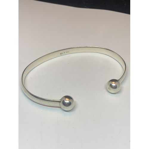 527 - TWO SILVER BANGLES TO INCLUDE A CHILDS WITH CHARMS