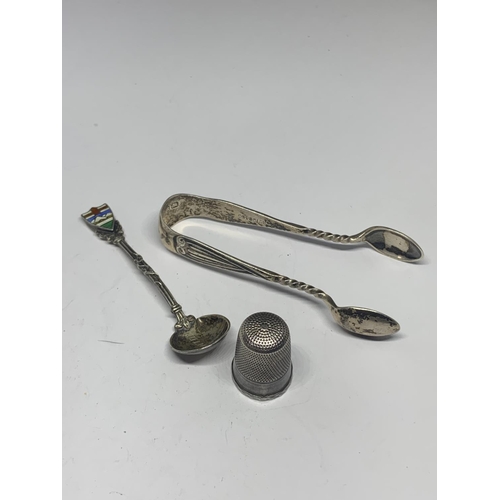 610 - THREE ITEMS OF SILVER TO INCLUDE A THIMBLE, SUGAR TONGS AND A SPOON