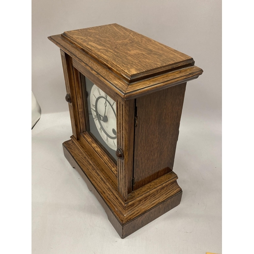 17 - AN EARLY 20TH CENTURY JUNGHANS, GERMAN, OAK CASED CHIMING MANTLE CLOCK WITH KEY