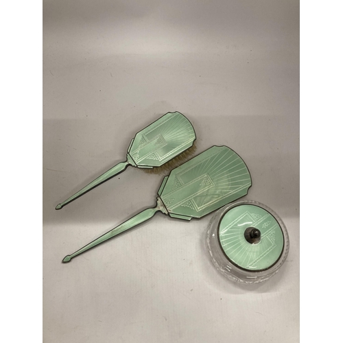 25 - AN ART DECO HALLMARKED SILVER AND FLORAL GREEN ENAMEL THREE PIECE DRESSING SET