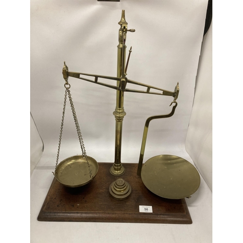 50 - A VINTAGE SET OF WEIGHING SCALES WITH PANS AND GRADUATED SET OF FIVE WEIGHTS