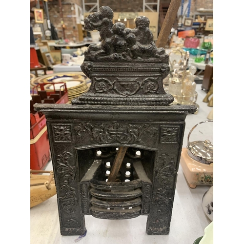 195 - A VINTAGE MINIATURE CAST FIREPLACE WITH POKER HEIGHT 31CM, WIDTH 19CM