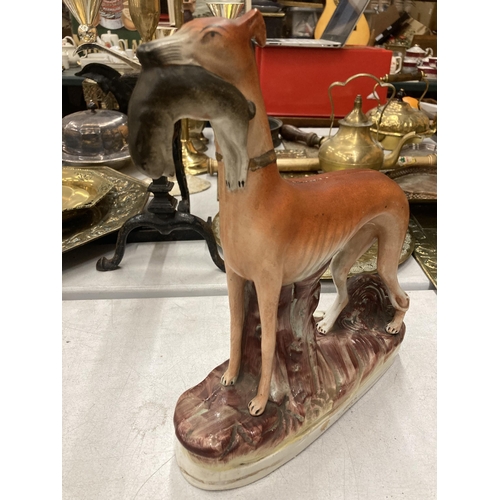 819 - A VINTAGE STAFFORDSHIRE GREYHOUND WITH RABBIT - A/F LARGE CRACK DOWN BODY HEIGHT 29CM