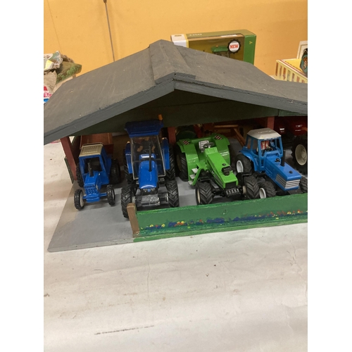 879 - A WOODEN TRACTOR GARAGE CONTAINING A QUANTITY OF TRACTORS AND TRAILERS