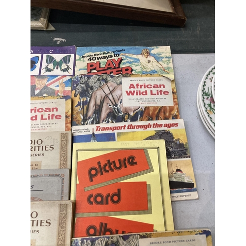 958 - A LARGE QUANTITY OF CIGARETTE CARD ALBUMS TO INCLUDE BRITISH COSTUME, PREHISTORIC ANIMALS, AFRICAN W... 