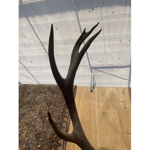 1508 - A PAIR OF ANTLERS MOUNTED ON A WOODEN PLINTH