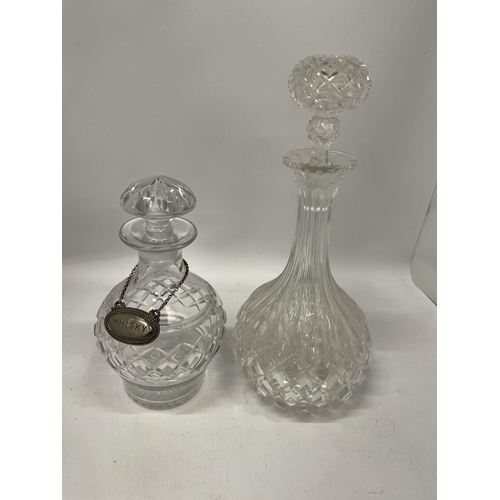 52 - TWO CUT GLASS DECANTERS TOGETHER WITH A VINTAGE SILVER PLATED WHISKY DECANTER LABEL