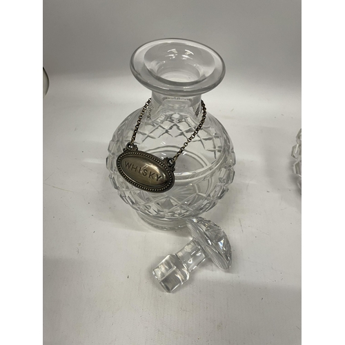 52 - TWO CUT GLASS DECANTERS TOGETHER WITH A VINTAGE SILVER PLATED WHISKY DECANTER LABEL