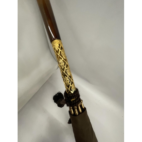 58 - A VINTAGE PARASOL WITH DECORATIVE YELLOW METAL FERRULE AND AMBER EFFECT HANDLE