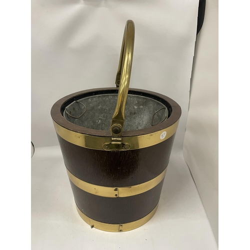 69 - A VINTAGE OAK AND BRASS BOUND BUCKET WITH BRASS HANDLE AND INNER GALVANISED LINER