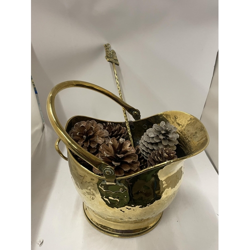 75 - A VINTAGE HAMMERED EFFECT BRASS COAL BUCKET FILLED WITH PINE CONES