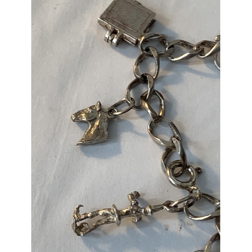 641 - A SILVER CHARM BRACELET WITH TEN CHARMS