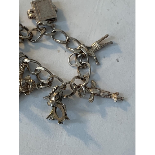 641 - A SILVER CHARM BRACELET WITH TEN CHARMS