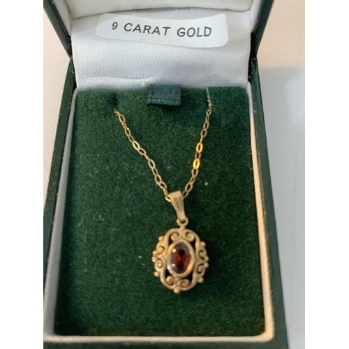 643 - A 9 CARAT GOLD NECKLACE WITH RED STONE PENDANT IN A PRESENTATION BOX