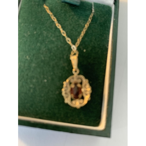 643 - A 9 CARAT GOLD NECKLACE WITH RED STONE PENDANT IN A PRESENTATION BOX