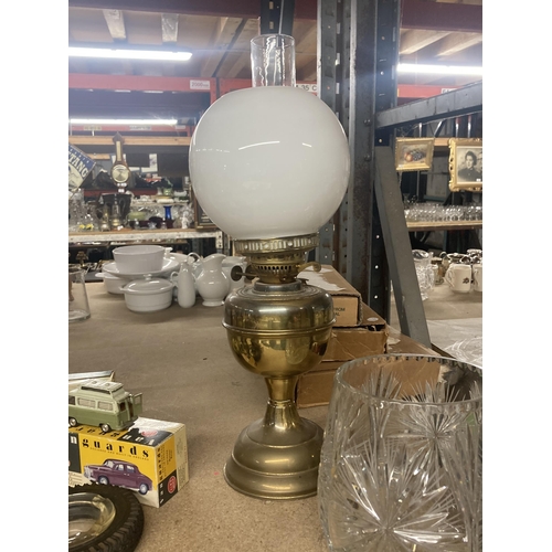 1070 - A VINTAGE OIL LAMP WITH BRASS BASE, WHITE SHADE AND GLASS FUNNEL TOGETHER WITH A CRYSTAL VASE