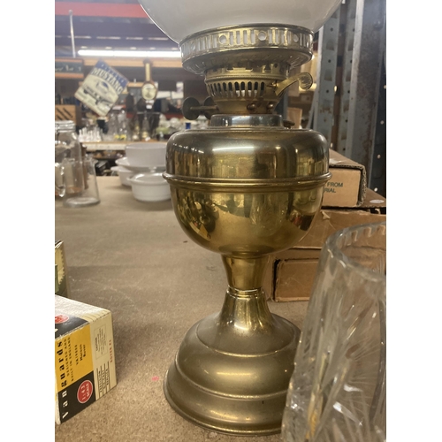 1070 - A VINTAGE OIL LAMP WITH BRASS BASE, WHITE SHADE AND GLASS FUNNEL TOGETHER WITH A CRYSTAL VASE