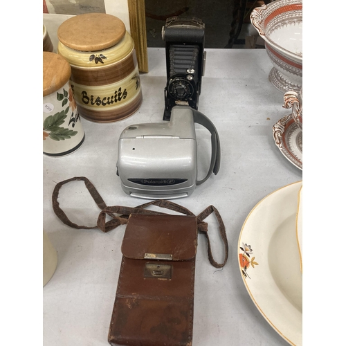 1104A - A VINTAGE KODAK CAMERA WITH BELLOWS AND LEATHER CASE AND A POLAROID CAMERA