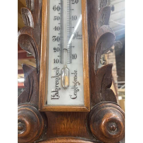 1119 - A W W GOLDSTRAW ANEROID BAROMETER IN A CARVED MAHOGANY CASE