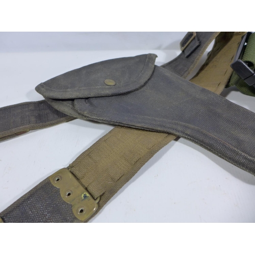 353 - A MILITARY ISSUE CANVAS BELT AND HOLSTER AND A CAMOUFLAGE BELT PACK (2)