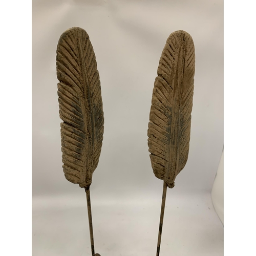 168 - A PAIR OF DECORATIVE STONE FEATHERS ON STANDS