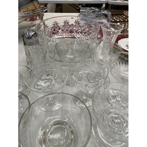 215 - A QUANTITY OF GLASSWARE TO INCLUDE LARGE BOWLS, DESSERT BOWLS WITH ENGRAVED AND ETCHED DESIGN, A VAS... 