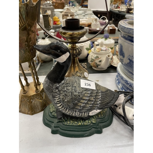 236 - THREE ITEMS - A CAST DUCK DOORSTOP, LAMP & BRASS VASE ON STAND