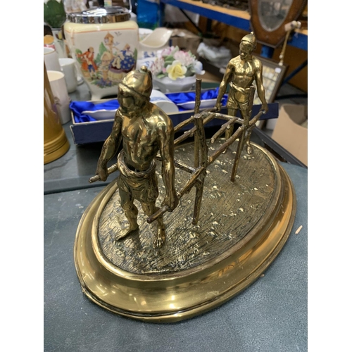 104 - A BRASS FIGURE GROUP OF TWO COOLIES CARRYING A STRETCHER HEIGHT 16CM, LENGTH 29CM