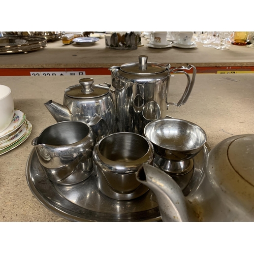 1127 - A STAINLESS STEEL TEASET ON A TRAY, A PICQUOT WARE TEAPOT, ETC