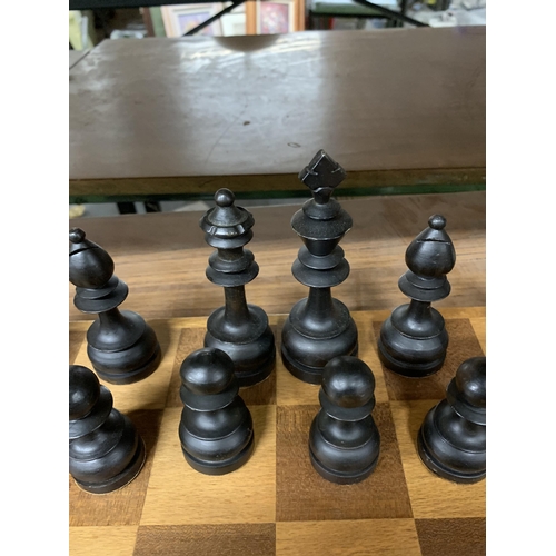 1138 - A LARGE WOODEN CHESSBOARD WITH A FULL SET OF WOODEN CHESS PIECES