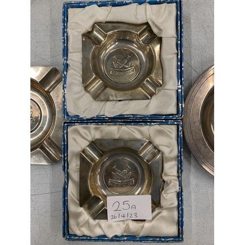 25A - THREE SILVER PLUS ONE WHITE METAL ASHTRAYS WITH MILITARY EMBLEMS