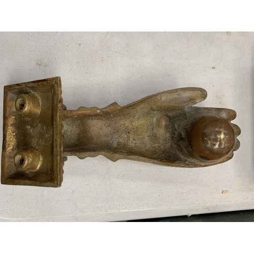 133 - A VINTAGE BRASS DOOR KNOCKER IN THE SHAPE OF A HAND