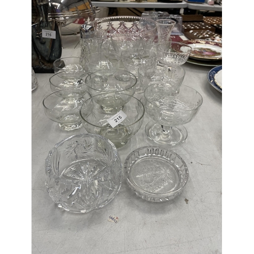 215 - A QUANTITY OF GLASSWARE TO INCLUDE LARGE BOWLS, DESSERT BOWLS WITH ENGRAVED AND ETCHED DESIGN, A VAS... 