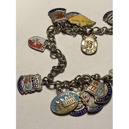 612 - A SILVER CHARM BRACELET WITH EIGHTEEN CITY AND PLACES CHARMS