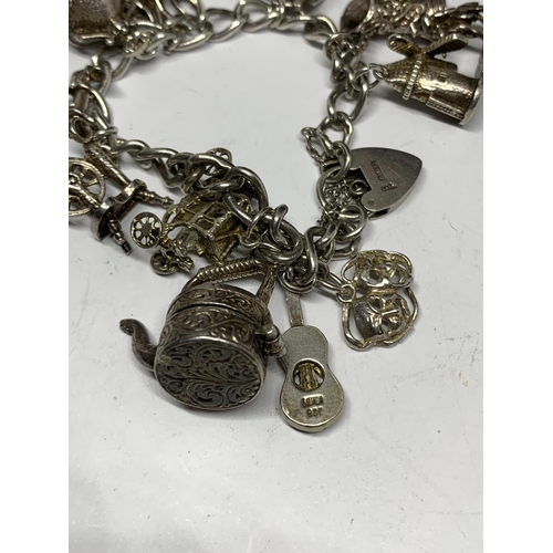 642 - A SILVER CHARM BRACELET WITH TWELVE LARGE CHARMS